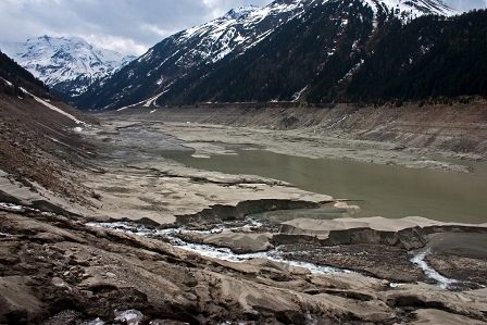 Der Gepatsch Speichersee als Schlammwüste mit ganz wenig Wasser. Im Hintergrund Berge